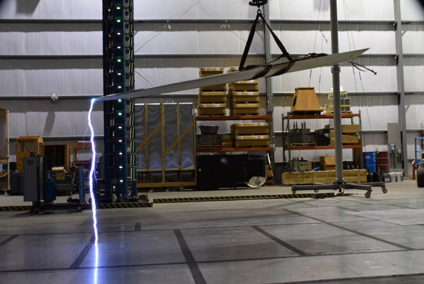 A blade hanging in a warehouse with electricity arcing from the tip to the floor