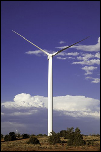 A photo of a large wind turbine surrounded by desert landscape. 