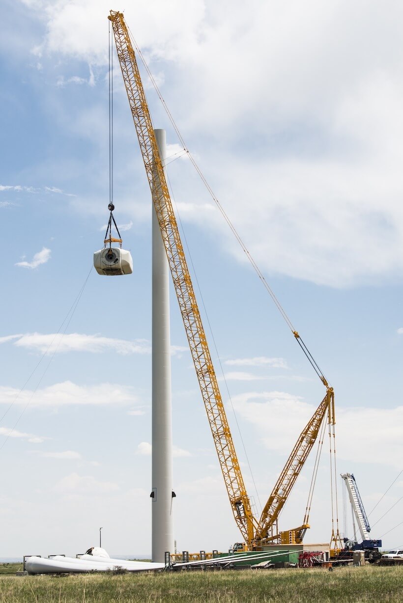 A crane assembles a wind turbine.