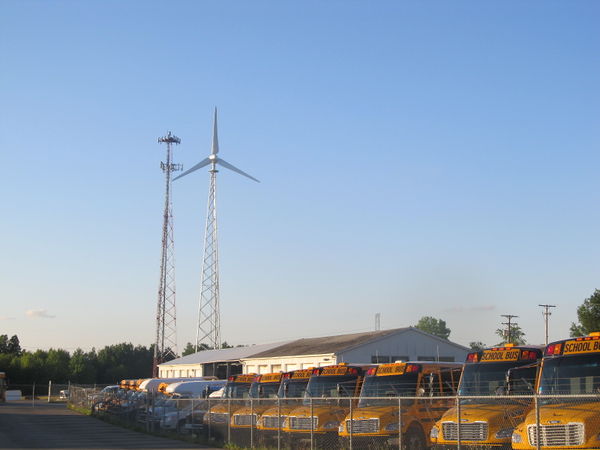 photo of a wind turbine and school buses