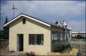 A photo of technicians on the roof of the greenhouse installing a pv panel.